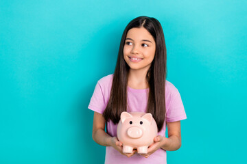 Wall Mural - Photo of funny schoolgirl hold piggy bank collect more money for dream look empty space amusement park isolated on cyan color background