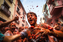 People Enjoy The Unique Atmosphere La Tomatina Festival. Young People Happily Throw Tomatoes. Traditional Spirited Celebration At Tomatina Festival In Bunol, Located In The Valencia Region Of Spain