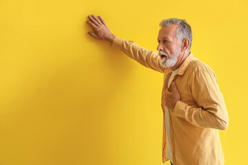 Sticker - Mature man having heart attack on yellow background