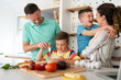 © Dorde - Young happy parents and their sons enjoying family time while preparing lunch in the kitchen.