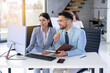 © Bojan - Business man and woman sitting in front of computer and working together on a project, discussing business strategy that aims to produce results for a company.