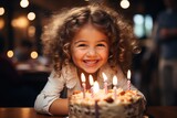 Fototapeta Sypialnia - Child blowing out candles on a birthday cake - stock photography