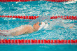 Swimmer boy swims backstroke swimming style in the pool