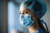 Fototapeta Lawenda - Side view of young female surgeon during surgery