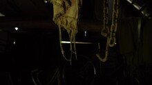 Rusty Chains Hang From The Ceiling And Dangle In An Abandoned Basement, A Metal Chain And Rusty Hook Move In An Old Barn