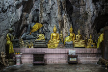 Golden Buddha Statue In A Cave In A Jungle Temple In Thailand.