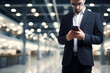 © sam - Male professional holding a mobile phone in an office