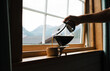 © Cavan - person pouring black coffee in a mug in a cabin in Norway