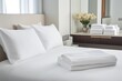 © altitudevisual - crisp white hotel-style bed with folded towels