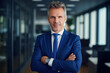 © Elaine - Businessman Ceo standing in office arms crossed pose