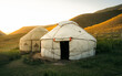 Yurt nomadic houses camp at mountain valley in Central Asia during sunset or sunrise 