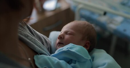 woman in the maternity hospital holds and swings a newborn baby