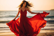 Attractive Woman In Red Dress Dancing On The Beach