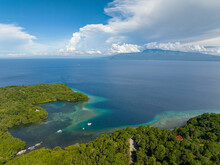 Tropical Island With Turquoise Water At Coast. Boat Over The Sea, Blue Sky And Clouds. Camiguin Island, Philippines.
