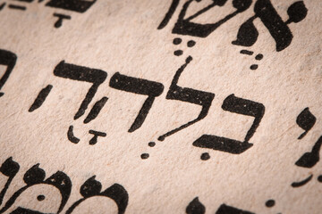Canvas Print - Closeup of hebrew word in Torah page. English translation is name Bilhah. Laban's handmaiden. Rachel's handmaid. Mother of Dan and Naphtali. Selective focus.