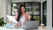 © bongkarn - A cheerful Asian businesswoman looking at her laptop screen with an excited and happy face