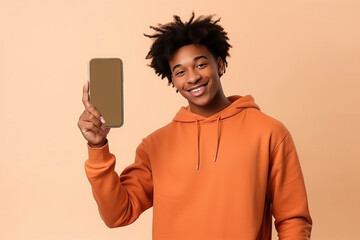 Happy African American teen student holding mobile cell phone pointing finger at smartphone mock up big screen template presenting application, using cellphone showing ad isolated on beige background.