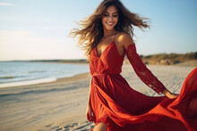 Attractive Woman In Red Dress Dancing On The Beach