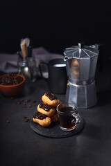 Wall Mural - Chocolate eclairs with a cup of coffee and a coffee pot