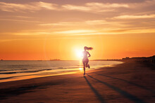 Woman Jogging On The Beach In Evening. Generated Ai