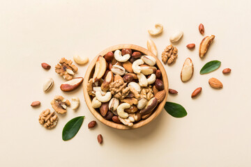 Sticker - mixed nuts in bowl. Mix of various nuts on colored background. pistachios, cashews, walnuts, hazelnuts, peanuts and brazil nuts