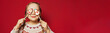 © millaf - Christmas child young girl maks a wish on red studio wall banner background with copy space