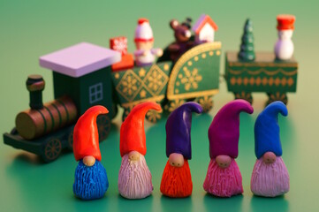 Sticker - Figures of dwarfs and a Christmas train on a green background. Christmas toys.