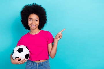 Sticker - Photo of good mood adorable girl wear pink t-shirt holding soccer ball indicating at sale empty space isolated on blue color background