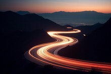 Long Exposure Image Of A Winding Road At Night With Moving Car Headlights