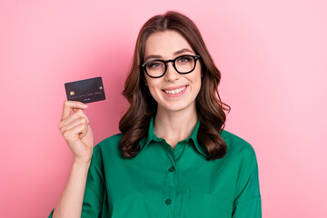 Canvas Print - Photo of pretty shiny lady wear green shirt eyeglasses smiling rising bank card isolated pink color background