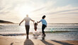 © Ramba/peopleimages.com - Mom, dad and swing girl on beach, holiday and vacation in Florida for bonding, adventure and family together in waves. Mother, father and child at sunset in ocean, sea or playing in water for fun