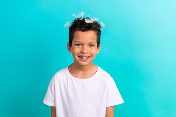 Portrait of cute cheerful kid toothy smile pillow feathers head have good mood isolated on turquoise color background