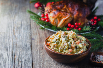 Wall Mural - Traditional Russian salad with cooked vegetables with mayonnaise in a bowl. Wooden background.