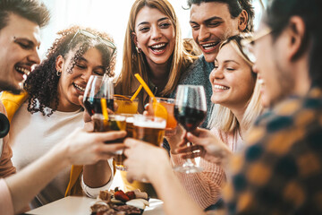 Wall Mural - Multiracial friends celebrating party drinking cocktails at bar restaurant - Young people having fun hanging out on weekend day - Life style concept with guys and girls enjoying time together