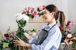 © Katcha - Female florist in apron holding white chrysanthemum with enjoying to creating and designing floral for