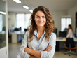 © Igor - Confident young businesswoman standing in a modern office