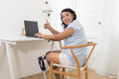 © amorn - Happy smiling Asian female with prosthetic leg sitting and working at home. Woman with prosthetic leg. Asian woman with leg prosthesis equipment