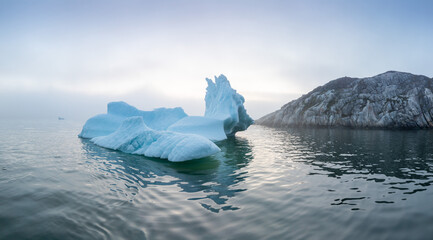 Wall Mural - Iceberg at sunset. Nature and landscapes of Greenland. Disko bay. West Greenland. Summer Midnight Sun and icebergs. Big blue ice in icefjord. Affected by climate change and global warming concept.