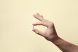 © New Africa - Man holding pill on beige background, closeup
