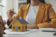 © Sirikarn Rinruesee - Real estate brokerage agent Deliver a sample of a model house to the customer, mortgage loan agreement Making lease and buy and sell house And contract home insurance mortgage loan concept