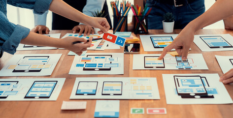 Wall Mural - panorama shot of front-end developer team brainstorming ui and ux designs for mobile app on paper wi