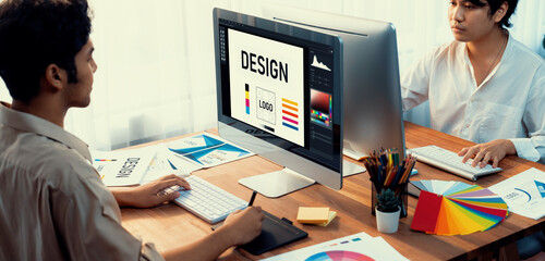 Poster - Graphic designer work on computer laptop and with graphic drawing pen while brainstorming unique design with professional graphic team in modern digital studio workplace. Panorama shot. Scrutinize