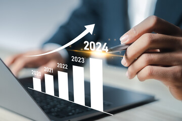 New year business goals 2024 and positive indicators 2024, businessman analyzing economic trend data for long-term investment. Development to success and motivation.