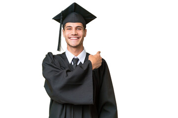 Wall Mural - Young university graduate caucasian man over isolated background pointing back