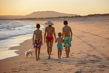 Poster - Happy children, boys, playing on the beach on sunset, kid cover in sand, smiling, laughing