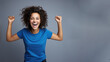 © pariketan - Young happy latin woman cheering at soccer sport match, blue t-shirt hispanic football fan supporter smile curly hair isolated on gray background