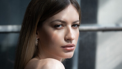 Beautiful young woman portrait in bright sunlight, contrast on the skin, bright highlights on the face