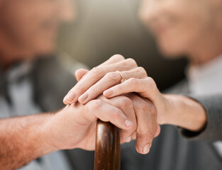 Holding hands, couple and a cane in nature for love, bonding and support. Peace, closeup and a senior man and woman in a park with a walking stick, care and together in a garden with trust on a date