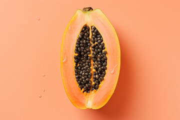 Wall Mural - half of yummy papaya fruit on a pastel coral background flat lay