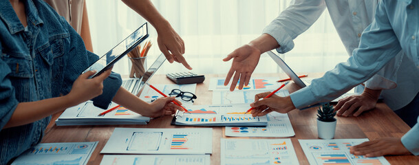 Leinwandbilder - Analyst team utilizing BI Fintech to analyze and pointing at financial dashboard paper office. Businesspeople examining report paper on table for business insight. Panorama shot. Scrutinize